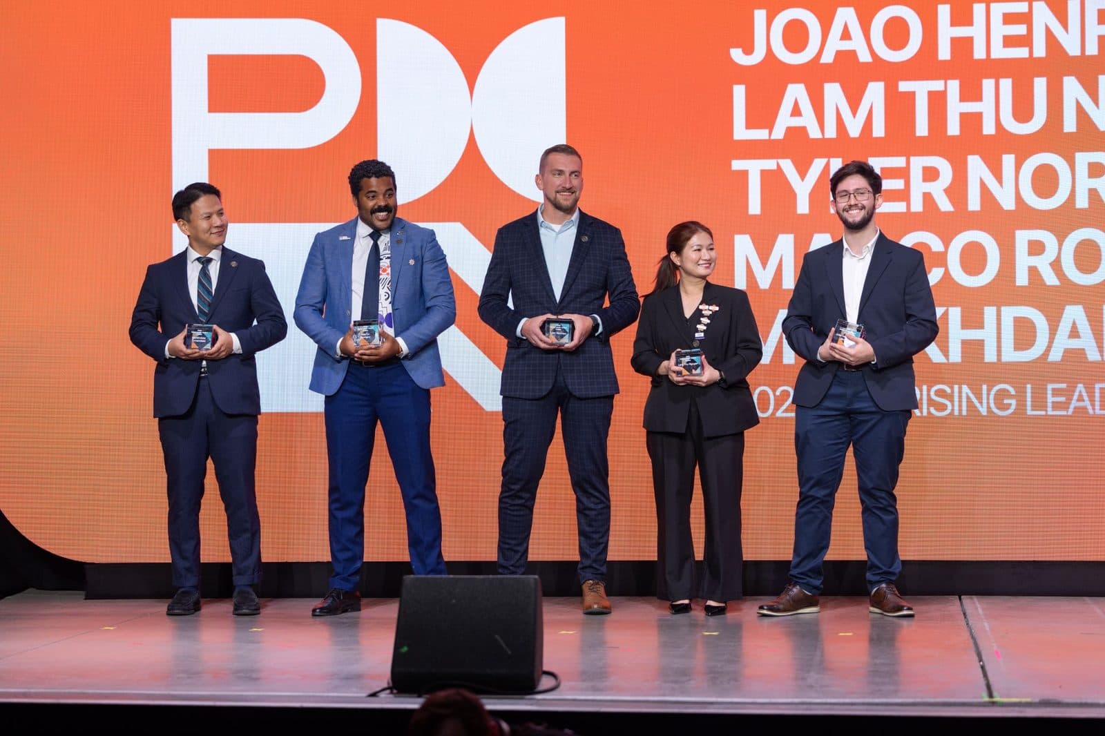 Finalistas do PMI Rising Leader Award no palco, com os nomes projetados no telão