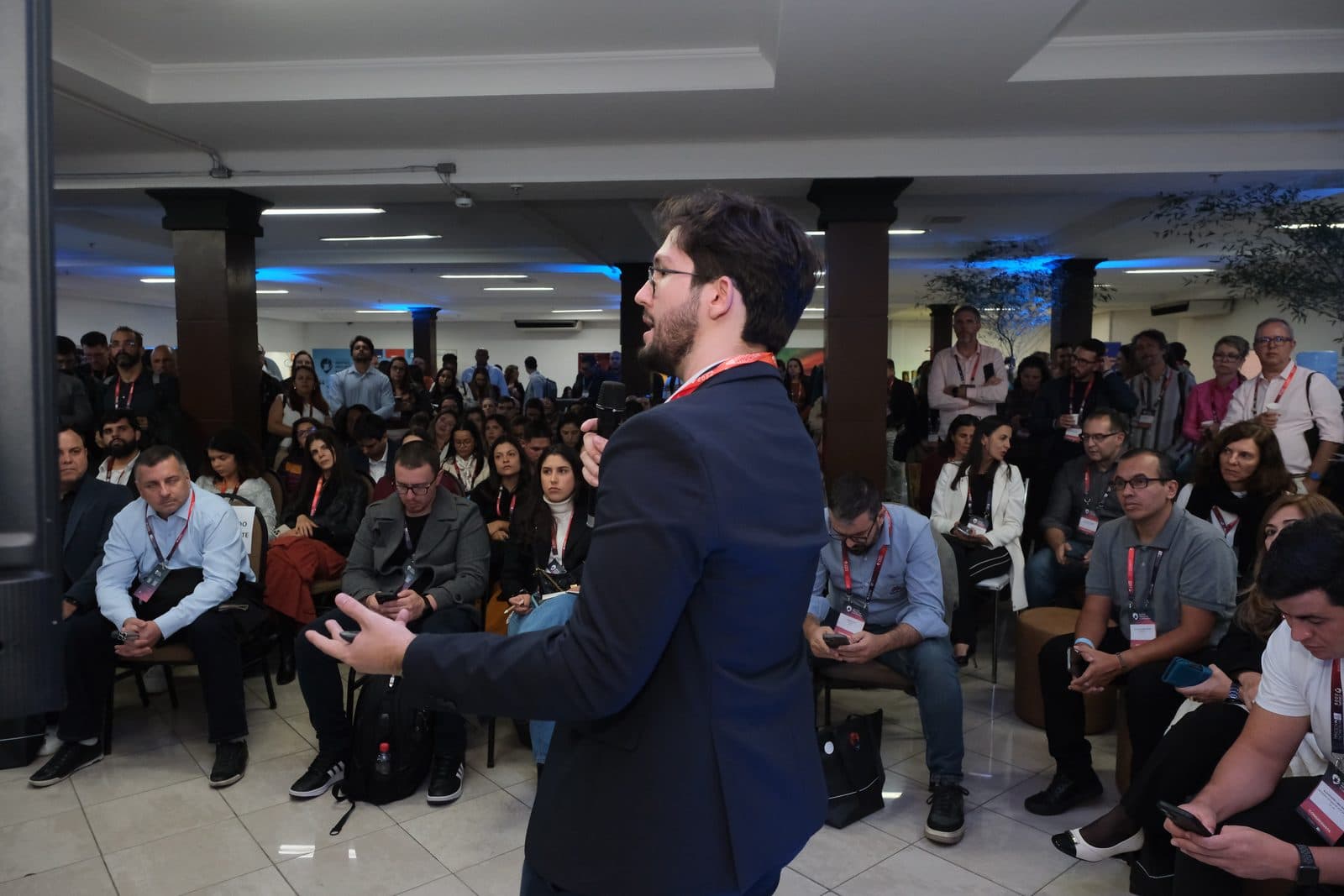 Sala cheia durante uma palestra, vista de dentro da plateia
